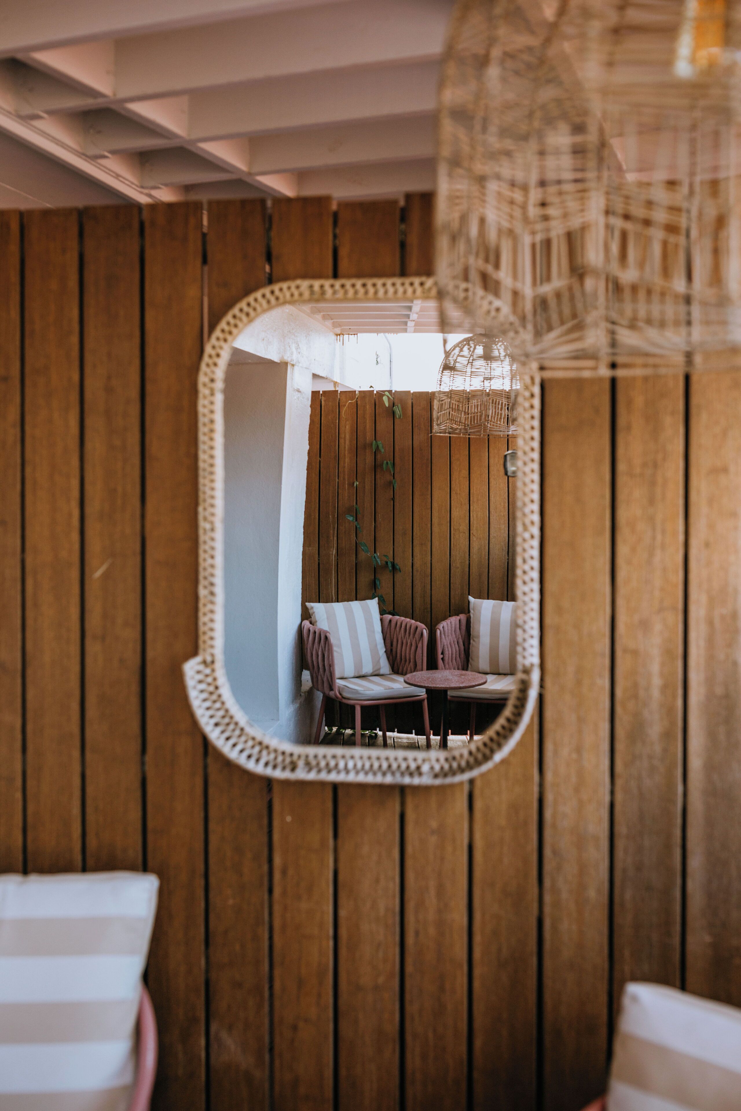 A room with a wooden panel wall, a round table with chairs, and a hanging light fixture.