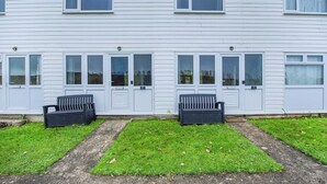 A two-story residential building with a symmetrical facade, featuring evenly spaced windows and doors. - 2 bedroom accommodation in Freshwater East, near Pembroke (Freshwater East, near Pembroke)