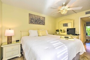 A bedroom with a bed, nightstand, lamp, television, and ceiling fan. - Comfortable Siesta Key Condo w/ Pool Access! (Siesta Key)