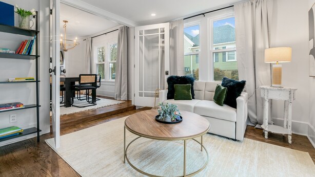 A spacious living room with a white sofa, a round coffee table, and a bookshelf. - Location!! - The Davidson - Charming Home in Fayetteville Historic District (Fayetteville)