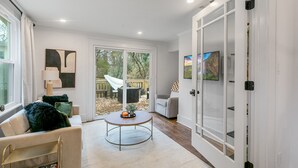 A spacious living room with a large sliding glass door leading to an outdoor area. - Location!! - The Davidson - Charming Home in Fayetteville Historic District (Fayetteville)