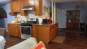 Una cocina compacta con armarios de madera, estufa integrada y microondas.