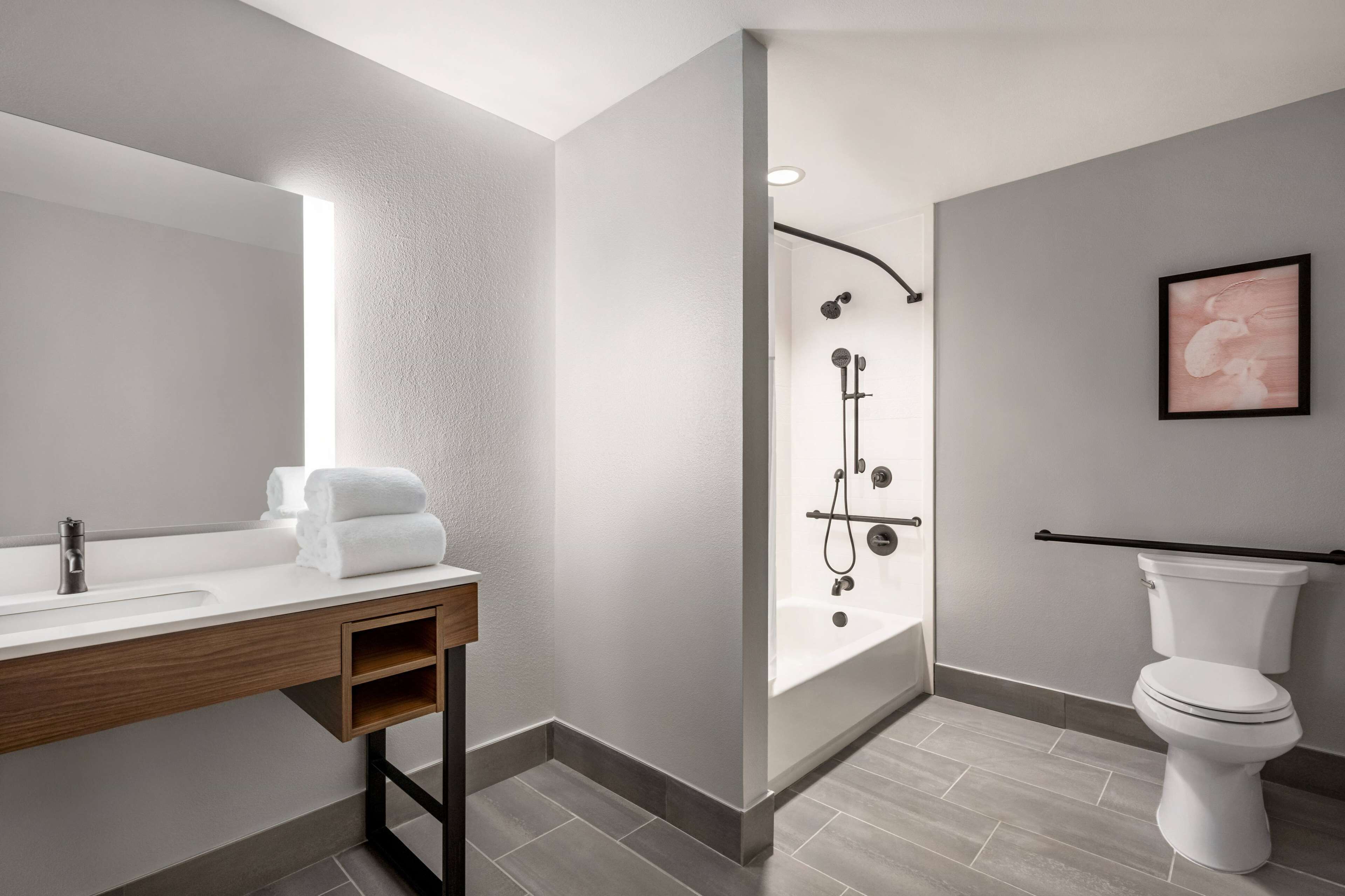 A modern bathroom with a shower, toilet, and sink.