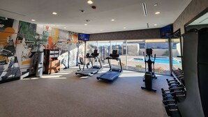 A gym with treadmills, dumbbells, and a view of a swimming pool. - La Quinta Inn & Suites by Wyndham Del Rio (Del Rio)