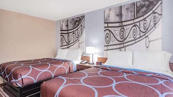 Une chambre d’hôtel avec deux lits, une table de chevet, une lampe et un mur orné d’un motif décoratif.