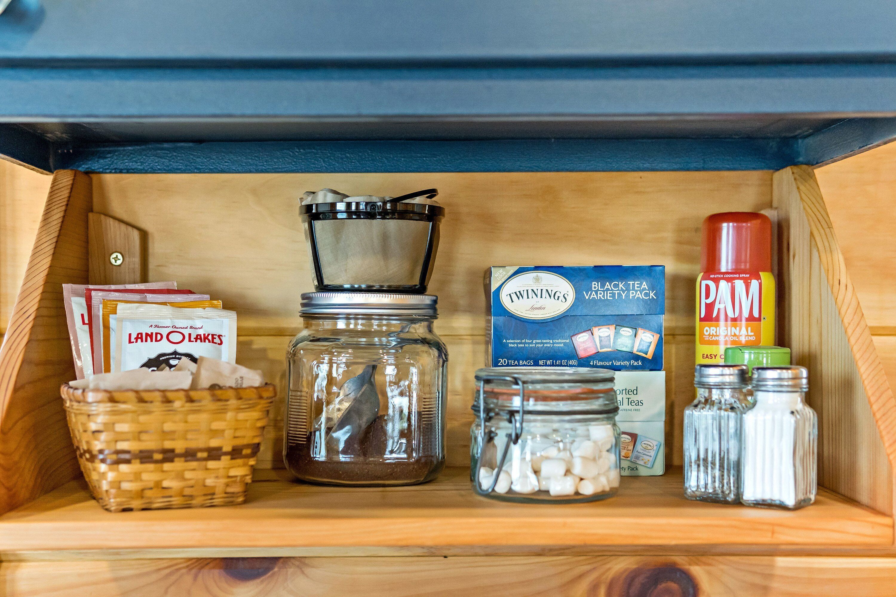 Open shelf stocked with coffee from a local roaster, teas, hot chocolate, etc.