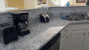 A kitchen with a coffee maker, blender, and dishwasher. There is a sink and a window with a view of the outside. - Comfy Luxury Vacation Getaway (Dumfries)