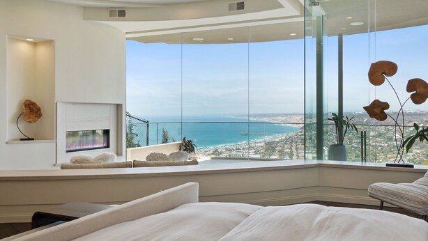 A modern bedroom with a large window overlooking a coastal cityscape. - La Jolla villa with 5 bedrooms, private pool, hot tub, and ocean views. (La Jolla)