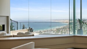 A high-rise room with a large panoramic window overlooking a coastal cityscape, featuring a clear view of the ocean and a bridge. - La Jolla villa with 5 bedrooms, private pool, hot tub, and ocean views. (La Jolla)