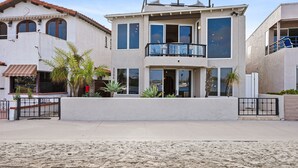 Ein zweistöckiges Haus mit Balkon, großen Fenstern und einem ehrfurchtgebietenden Eingangstor.