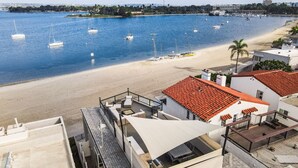Ein Hotel an der Küste mit einer Dachterrasse mit Blick auf Strand und Hafen.