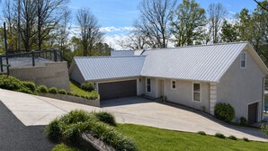 A residential house with a garage, a driveway, and a landscaped front yard.