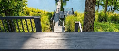 Una terraza de madera con vista a un lago y un muelle.