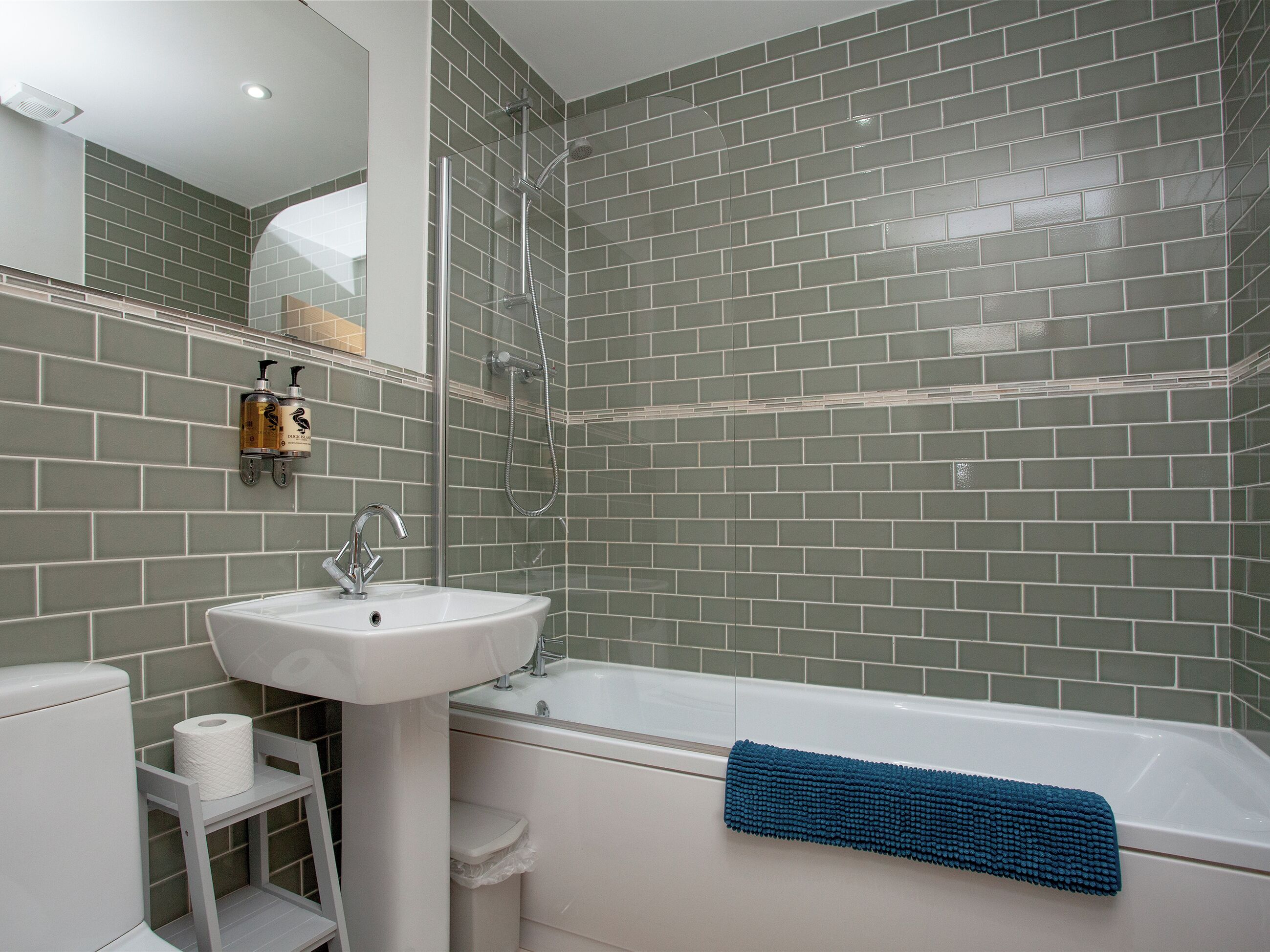 Une salle de bain avec un lavabo blanc, une baignoire et une douche.