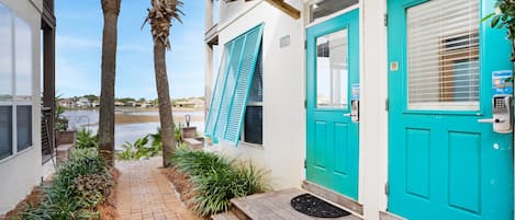 A turquoise door with a mailbox and a small outdoor seating area.