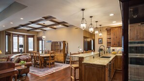 A spacious kitchen with wooden cabinets, a large island, and pendant lighting.