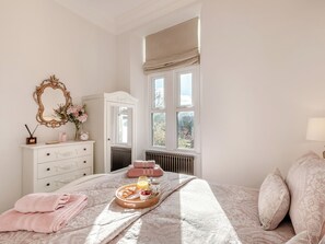 A bedroom with a bed, a dresser, a mirror, and a window. - 3 bedroom accommodation in Wooler (Wooler)