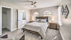 A bedroom with a bed, a ceiling fan, two bedside tables, a nightstand, and a window with blinds. - 3-Story Houston Townhome: 1 Mi to Minute Maid Park (Houston)