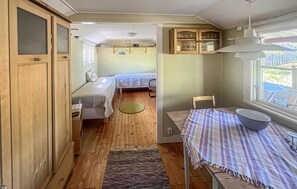 Interior compacto de una autocaravana con dos camas, zona de comedor y cocina con armarios.