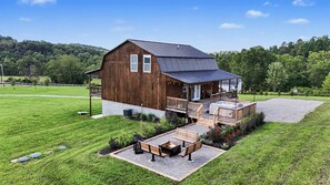 A large wooden barn with a covered porch and a hot tub. - Ridge top cabin with hot tub and movie theater (Logan)
