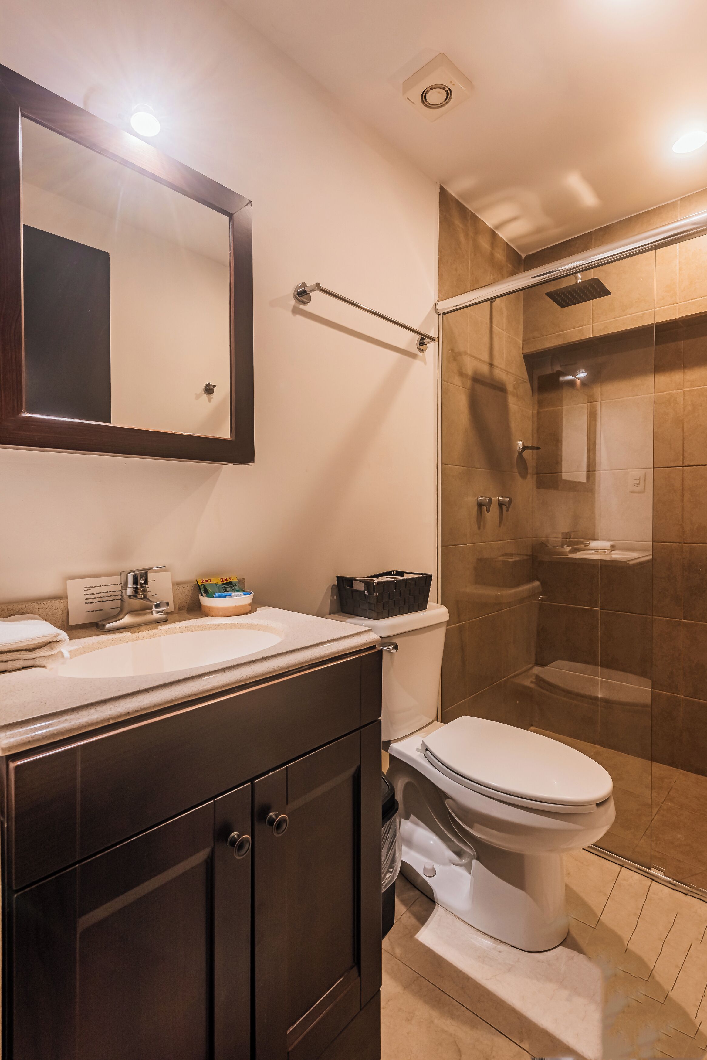 Een moderne badkamer met toilet, wastafel en douche.