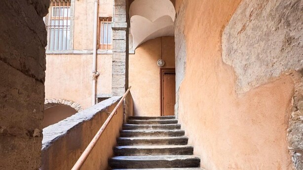 A stone staircase in a narrow corridor with a door at the top. - Opéra 9 - Great studio Opéra/Hôtel de Ville (Lyon)