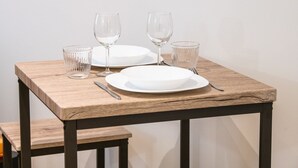 A wooden table with two white plates, two clear glasses, and a fork. - Opéra 9 - Great studio Opéra/Hôtel de Ville (Lyon)