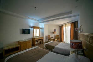 A hotel room with two beds, a desk, a chair, a television, and a lamp. - A pyramids view (Giza)