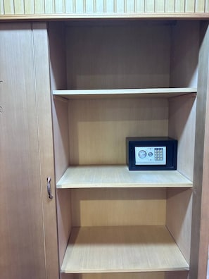 A wooden cabinet with three shelves, one of which contains a black safe. - A pyramids view (Giza)