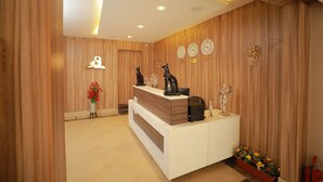 A reception desk with a white and wooden design, clocks on the wall, and a plant in the corner. - A pyramids view (Giza)