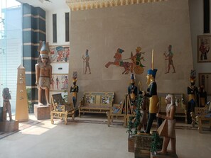 A museum interior with ancient Egyptian artifacts, including statues and wall paintings. - A pyramids view (Giza)