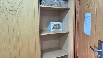 Un armario de madera con un diseño de corona, una caja fuerte pequeña y una nota en la puerta.