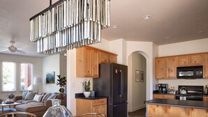 A modern kitchen with wooden cabinets, a black refrigerator, a microwave, and a coffee maker.