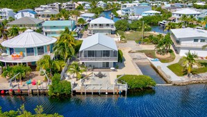 Zona residencial costera con casas, un muelle y un puerto deportivo.