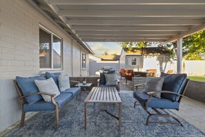 Relax in this serene outdoor space with a sofa, chairs, and a small table.