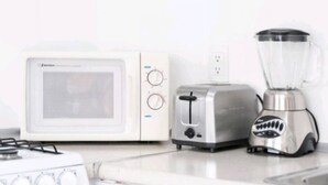 Eine Küche mit Mikrowelle, Toaster und Mixer auf der Arbeitsfläche.