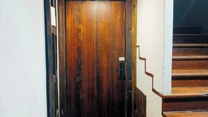 Eine Holztür mit einem Metallgriff und einem Schild mit der Aufschrift 'LOFT 100'.