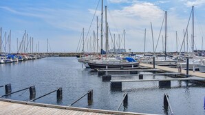 A marina with multiple boats docked, wooden walkways, and a clear sky. - 2 bedroom awesome apartment in Ystad (Ystad)