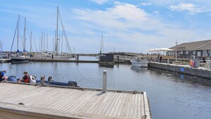 A marina with docked boats, a wooden pier, and a building with a sign. - 2 bedroom awesome apartment in Ystad (Ystad)
