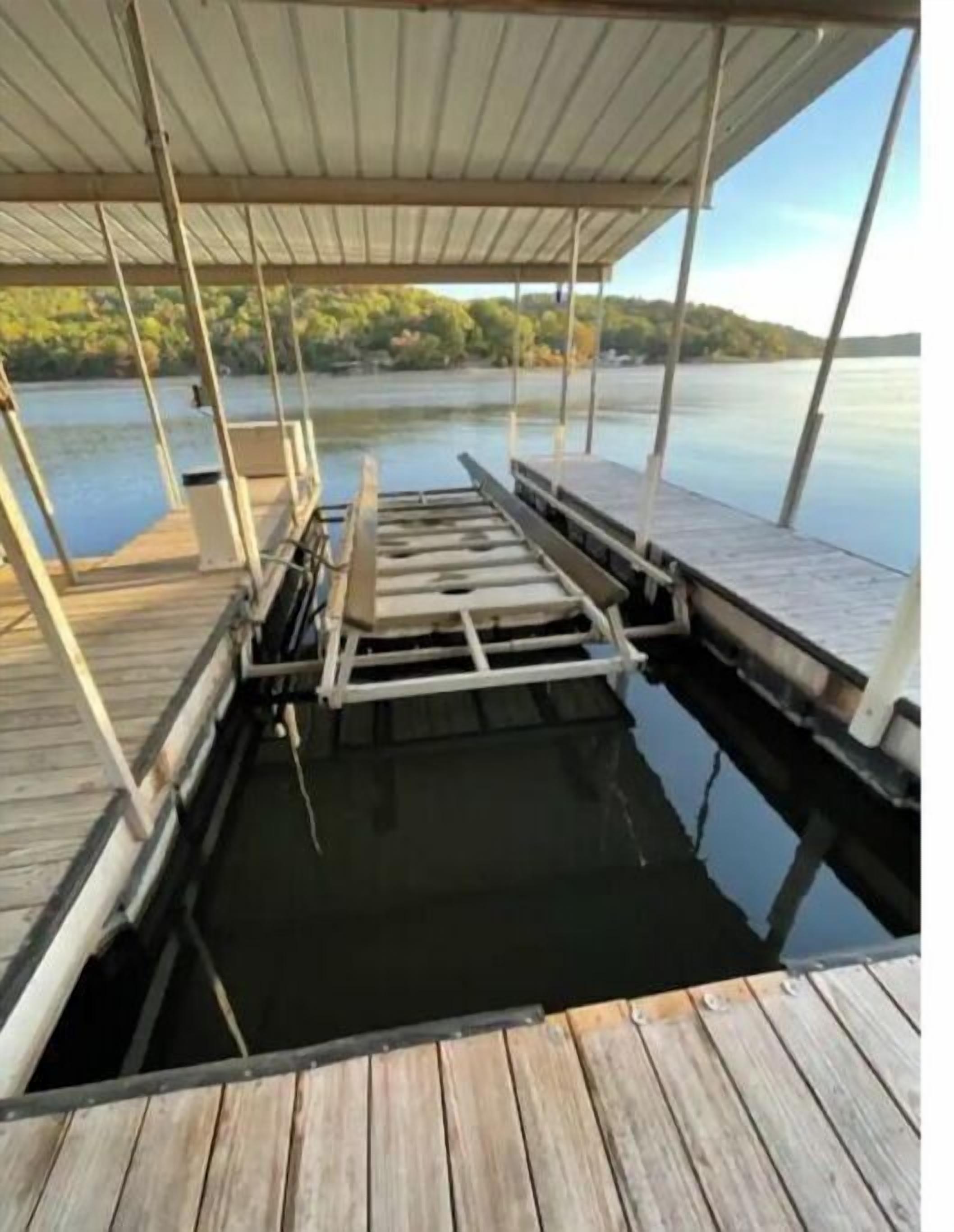 Une jetée en bois s’avançant dans un lac paisible, avec une zone abritée située au-dessus.