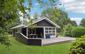 A modern house with a covered porch, a deck, and a well-maintained lawn. - 3 bedroom awesome home in Glesborg (Glesborg)