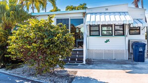 A white building with a blue awning, number 35, and a blue trash bin. - ISLE BE BACK To The Sunny Keys (Cudjoe Key)
