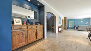 A spacious living area with a wooden cabinet, a stone fireplace, and a blue accent wall. - Stunning home in Fayence with sauna (Fayence)