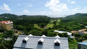 Ein Wohngebiet mit Häusern, einem Golfplatz und einem Gewässer im Hintergrund.