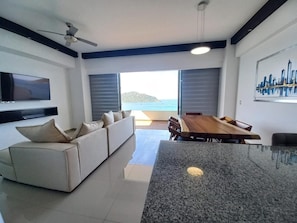 Suite Deluxe | Zona de estar | Smart TV de 65 pulgadas con canales por satélite