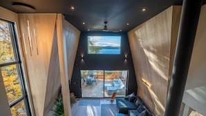 Ein modernes Interieur mit einem großen Fenster, einem Deckenventilator und Blick ins Freie.