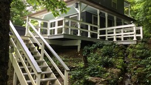 A two-story house with a balcony and a staircase leading up to it.