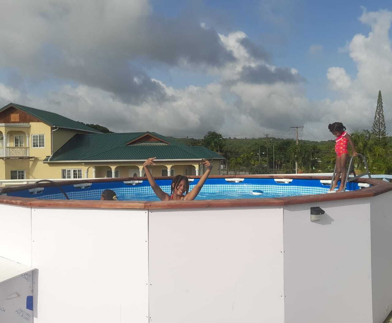 Una piscina con vistas a un edificio y árboles al fondo.