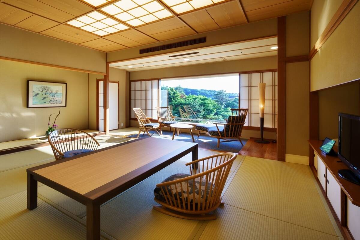 A traditional Japanese room with tatami flooring, a low table, and wooden furniture.