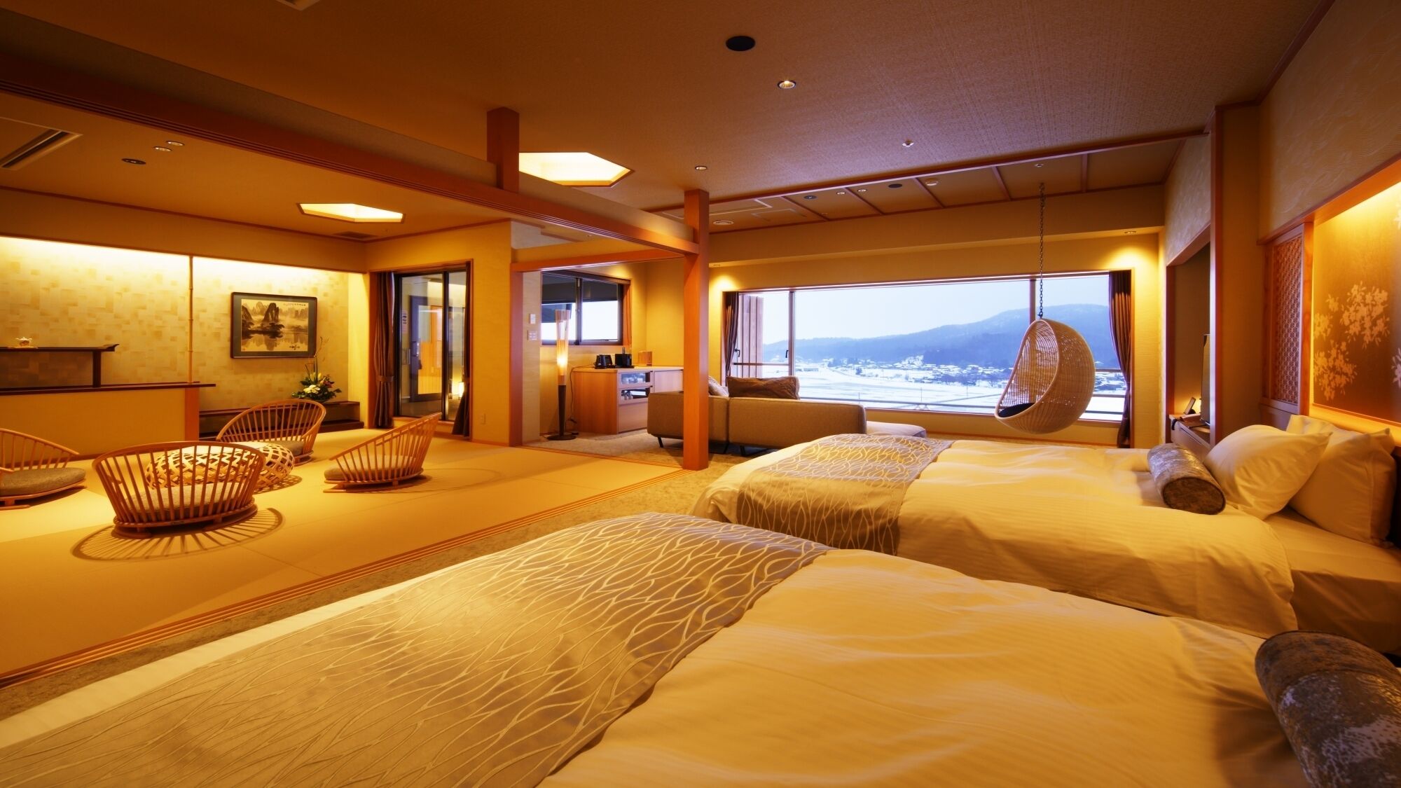 A hotel room with two beds, a sitting area with chairs, a desk, and a large window with a view.